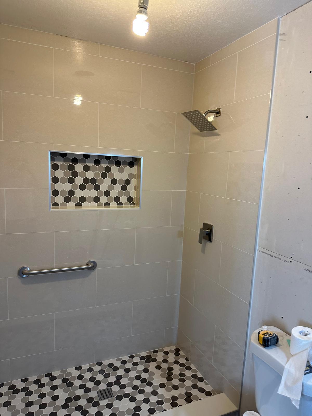 Accessible shower with a blocked and rated grab bar