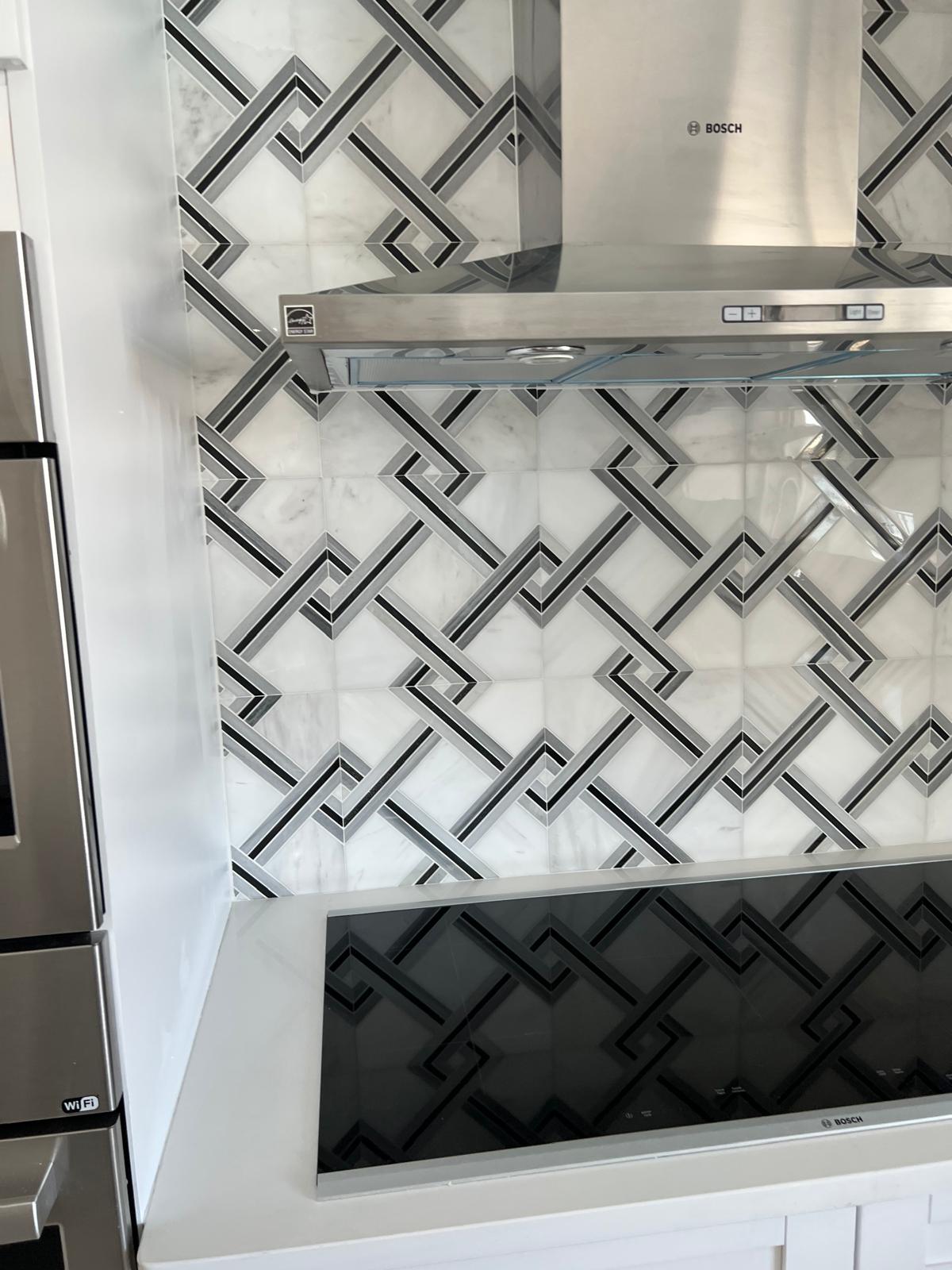 Waterjet marble and metal lattice backsplash across a full range wall