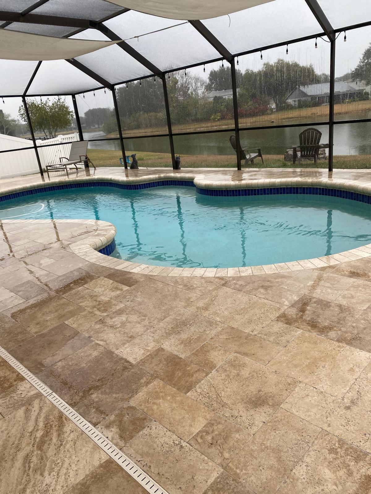 Travertine paver pool deck inside a screened lanai