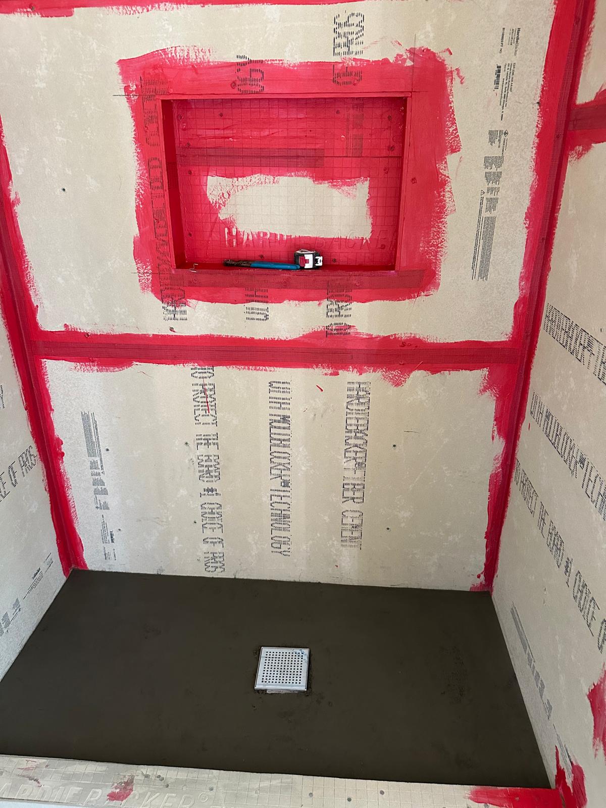 Bonded waterproofing membrane applied over cement board with a framed shower niche