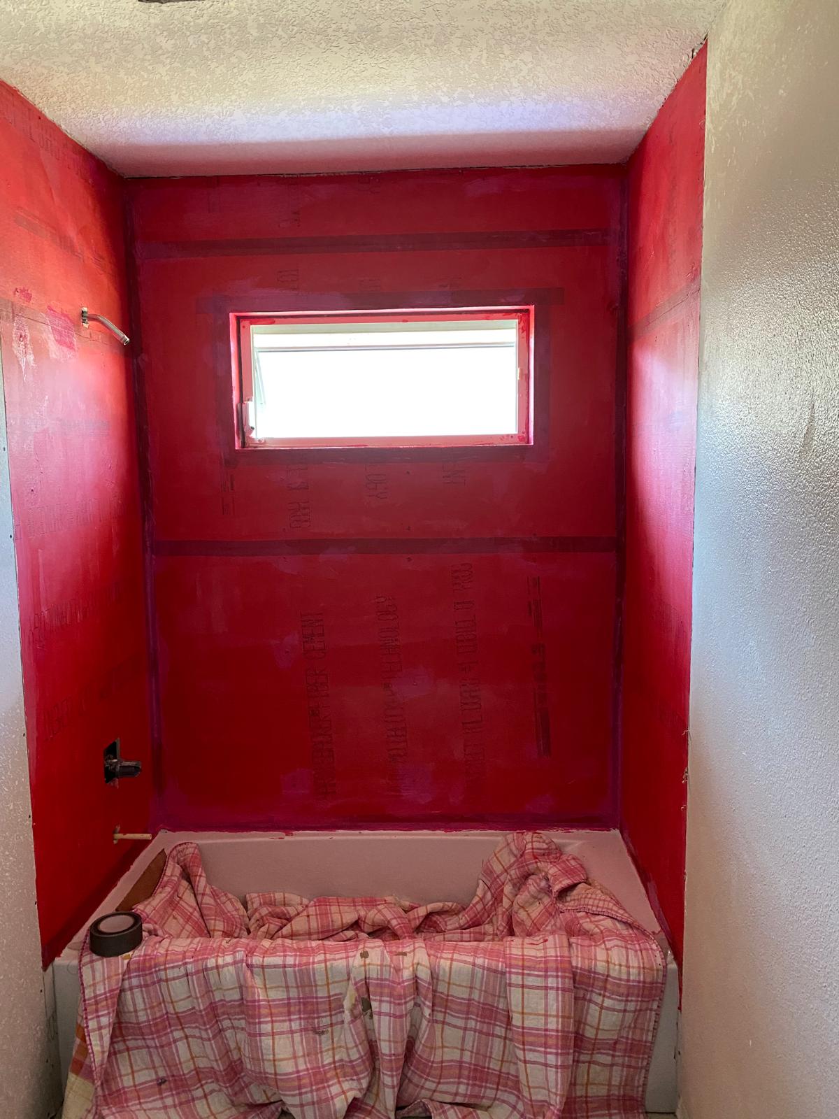 Tub alcove fully coated in waterproofing membrane before tiling